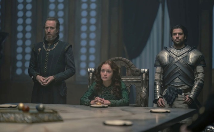 Una donna e due uomini siedono a un tavolo nella Casa del Drago.