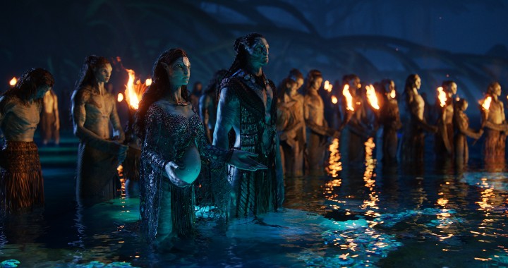 Un gruppo di Na'vi piange nell'acqua mentre le fiamme si mostrano intorno a loro in una scena di Avatar: The Way of Water.