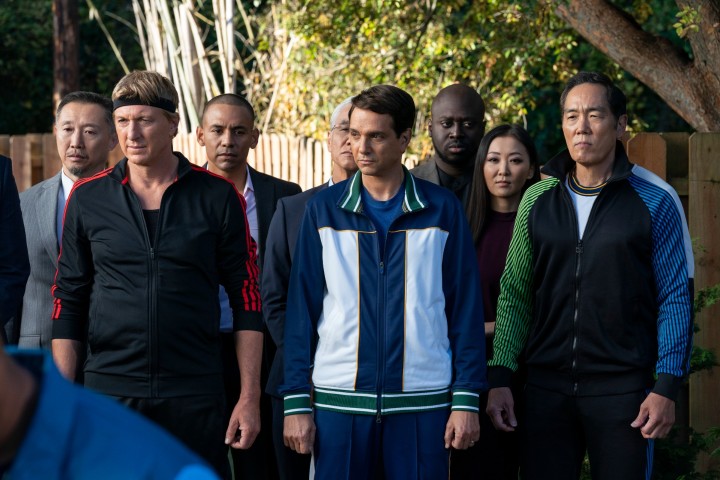 William Zabka, Ralph Macchio e Yuji Okumoto indossano tute da ginnastica in una scena della quinta stagione di Cobr Kai.