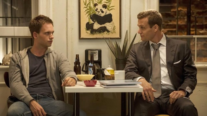 Mike e Harvey seduti uno di fronte all'altro a un tavolino in una scena di Suits.