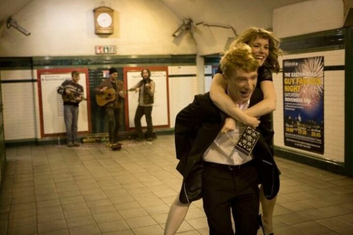 Un uomo trasporta una donna in About Time.