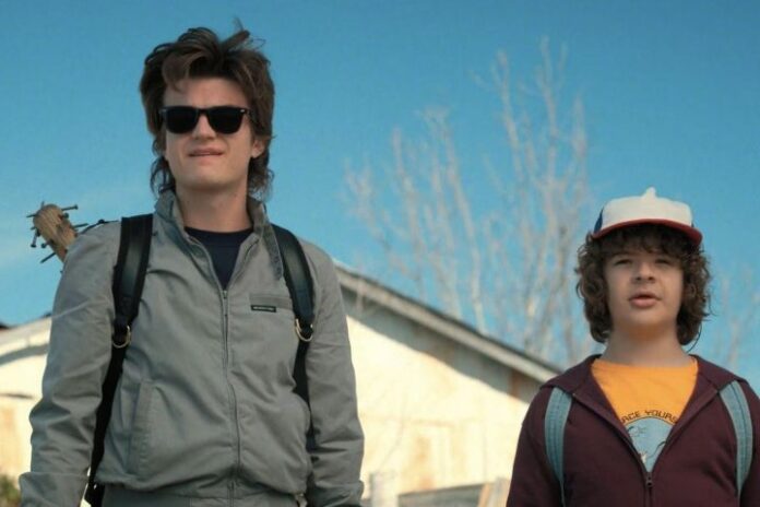 Steve e Dustin stanno uno accanto all'altro e fissano Stranger Things.