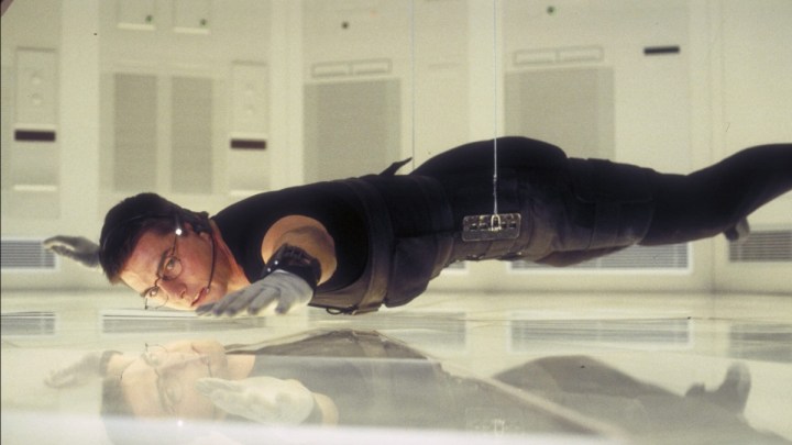 Tom Cruise nei panni di Ethan Hunt sospeso sul pavimento in Mission: Impossible.