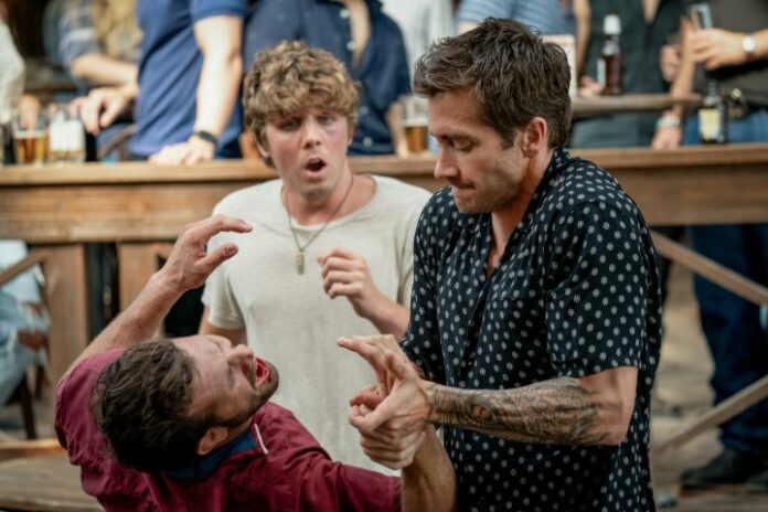 Lukas Gage guarda Jake Gyllenhaal rompere la mano a un ragazzo a Road House.