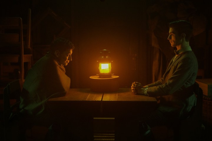 Due uomini siedono accanto a una lanterna in Dead Boy Detectives.