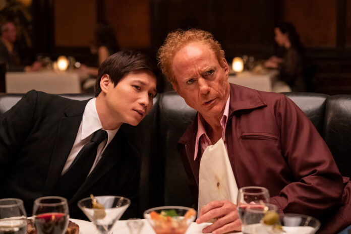 Hoa Xuande e Robert Downey Jr. siedono insieme a un tavolo da pranzo in The Sympathizer.