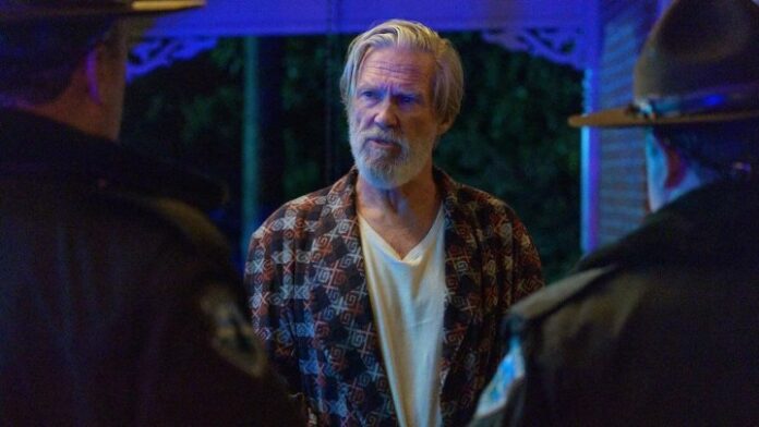 Jeff Bridges in The Old Man fissa due persone sulla soglia di casa sua.
